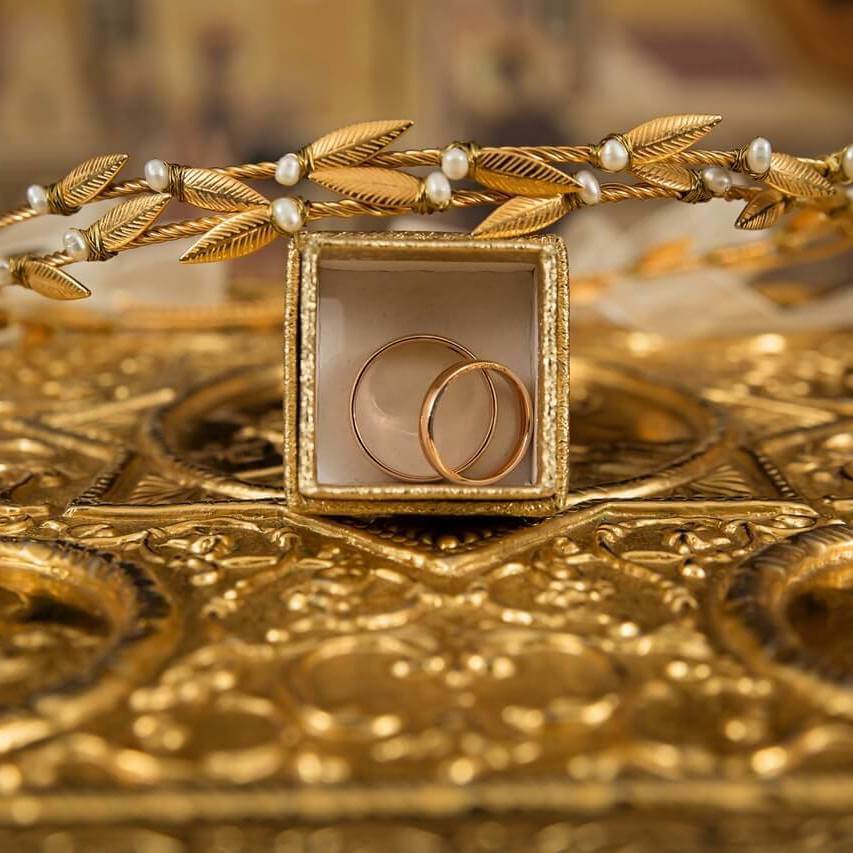 a gold crown and rings on top of a gold surface