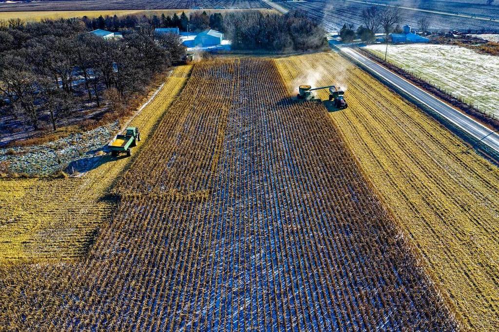 arial view of a farm being harvested by large trucks